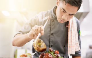 Overseas chef preparing speciality dish in restaurant kitchen