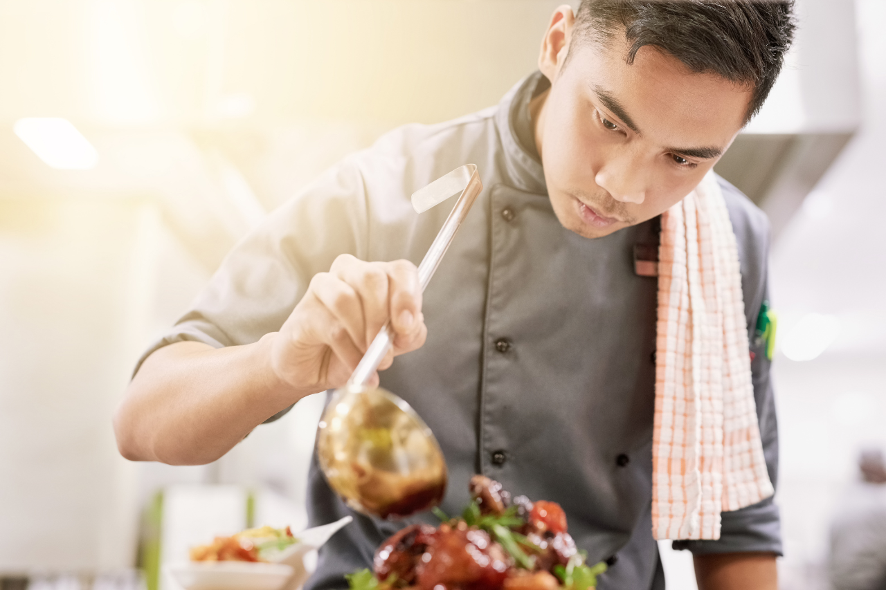Overseas chef preparing speciality dish in restaurant kitchen